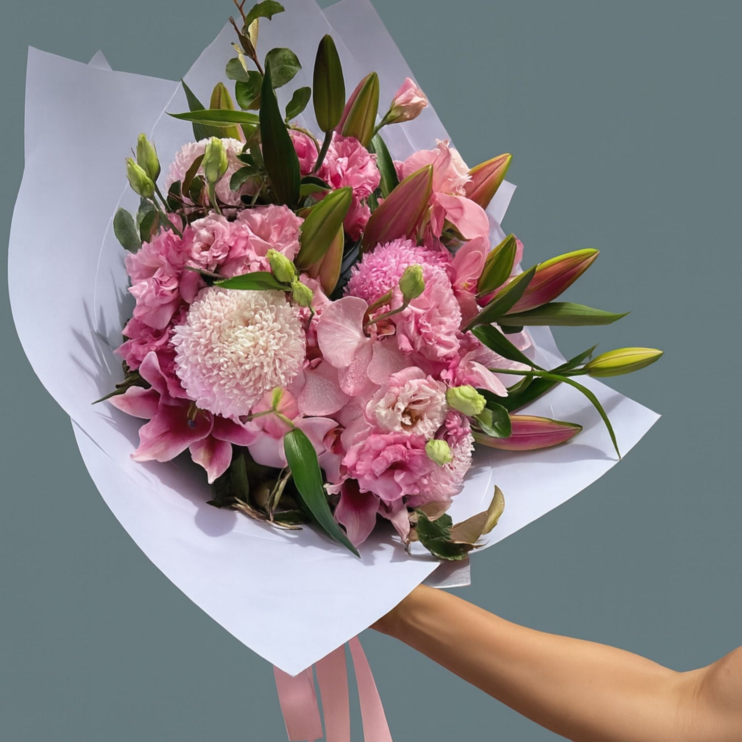 A woman earing black, holding a bouquet of Australian native wildflowers  in a bouquet.